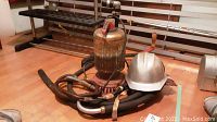 Front view of the vintage Franklin electric pump with attached hoses and white hard hat.