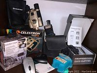 Lot overview showing Celestron VistaPix binoculars and box, Braun shaver box, professional hair clippers in packaging, and Logitech mouse.