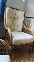 Front view of bamboo and wicker chair with beige cushions showing general condition