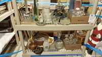 Shelf with assorted glassware including bowls, containers, and some decorative items.