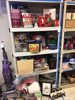 Shelves filled with various holiday decorations including cookie tins, ornaments, lights, candles, and plush figures