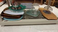 Wide view of various platters, bowls, trays, and jars on a shelf.