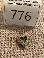 Front view of heart pendant on carpet showing open-heart design with surrounding diamond halo.