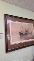 Framed boat wall art with a coastal freighter, showcasing the full artwork and frame.