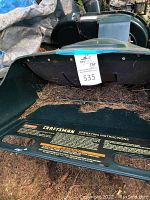 Green steel hopper section with Craftsman operating instructions label