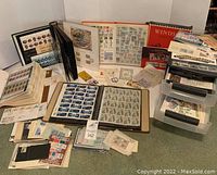 Overall view of multiple albums, folders, booklets and loose stamps spread on floor