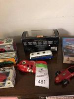 Overview of various boxed and loose toy vehicles including Maisto Ford Explorer model car, VW van, Chevron cars, and race cars.