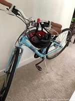 Front-quarter view of powder blue bicycle with helmet on handlebars