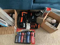 Photo showing black and orange multi-tool set, Eveready flashlights in packaging, and assorted hardware boxes