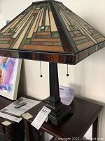 Side view of Tiffany style table lamp showing stained glass shade and metal base.