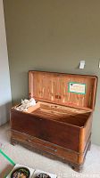 Full view of open cedar chest showing cedar interior and wood exterior, with a note on the underside of the lid.