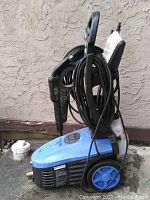 Full view of blue Simoniz ST700 pressure washer with hose and brush attached.