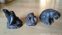 Photo showing three soapstone animal sculptures: two seals, a dog's head, and a sitting bear.