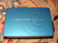 Blue Acer Aspire One laptop top lid with Aspire One branding visible.