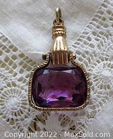 Front view of antique rolled gold hand watch fob pendant with faceted rectangular amethyst glass stone.