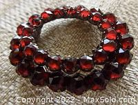 Close-up side angled view showing layered garnet stones and setting detail