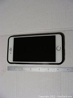 Top view of iPhone 6 Plus showing screen off and ruler for size reference