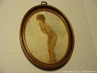 Oval framed print of nude woman by Paul Chabas showing front view of artwork and frame.