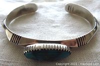 View of the inside and outside of the band showing the stamped signature Denetdale Navajo and polished silver finish.