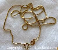 Full view of the 18 inch yellow gold box link chain necklace laid out on fabric background showing length and style.
