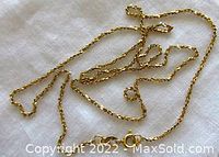 Full view of vintage 10K yellow gold rope chain necklace laid out on white cloth, showing chain style and length.