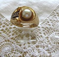 Frontal view of ring showing 6mm cultured pearl in convex bezel and channel-set diamonds on one shoulder