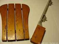 Front view of wooden canoe backrest with four vertical slats and metal canoe motor mount with wooden block.