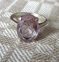 Front view of the vintage sterling silver ring showing the oval faceted light amethyst stone held by four prongs.