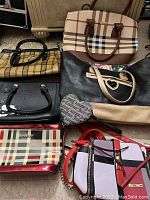 Eight women's handbags in various styles and faux designer-inspired patterns and colors.