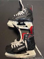 Pair of Bauer Vapor kids hockey skates size 6, black with white laces and blade holders, shown side profile