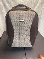 Front view of Bella Mia carry-on bag showing beige fabric with dark brown geometric pattern and leather-like side panels.