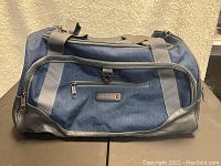 Front view of the blue-gray Swisstech Carry One bag showing fabric texture and zipper details.