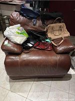 Brown leather reclining chair with items placed on it, showing the front view.