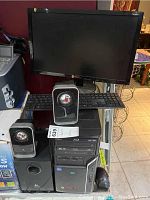 Photo of Acer desktop tower, Logitech subwoofer and satellite speakers, wired keyboard and mouse, and widescreen monitor.