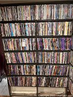 Full view of six shelves densely packed with DVD movies, showing the scale and volume of the collection.