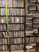 Photo showing multiple shelves densely packed with DVDs in plastic cases, spanning many titles and genres.