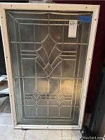 Front view showing decorative leaded glass design in wooden frame