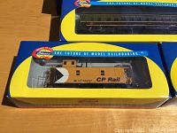 Photo showing CP Rail caboose model 434037 in original Athearn Genesis box with yellow and blue design.