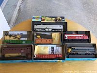 Six different Athearn miniature trains and train cars displayed in original boxes showing wear and some loose parts.