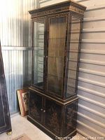 Overall front and right side view of cabinet showing two-tier design, glass doors, lower wood doors and side panel decoration