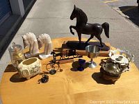 Overview of the lot showing all decorative items on wooden surface outdoors.