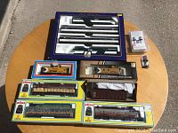 Overhead shot of entire lot on round table showing Lima set, Atlas boxes, signal kits, and TrueLine locomotive