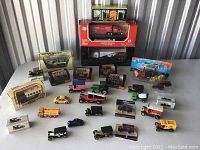 Full overview of assorted miniature models including agricultural equipment, vehicles, vintage and construction models, some boxed and some loose.