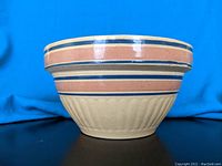 Side view of antique ceramic batter bowl showing ribbed texture and painted horizontal stripe design.