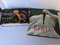 Two hardcover bird books side-by-side showing the front covers: "Birds of the World 365 Days" and "Robert Bateman Birds"