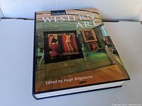 Front-facing view of the hardcover book 'The Oxford Companion to Western Art' showing the dust jacket with an image of an art museum interior.