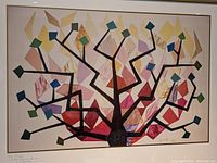 Framed art print depicting an abstract tree with colorful fabric applique shapes, signed by Karla Goldberg in 1985.