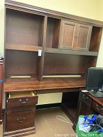 Full view of the desk with three drawers and open shelf area, showing wood grain and scratch marks