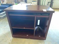 Front view of laminate computer desk with open compartments, visible scratches and wear on surfaces.