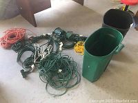 Photo showing all extension cords, two timers, and two trash bins arranged on concrete floor.